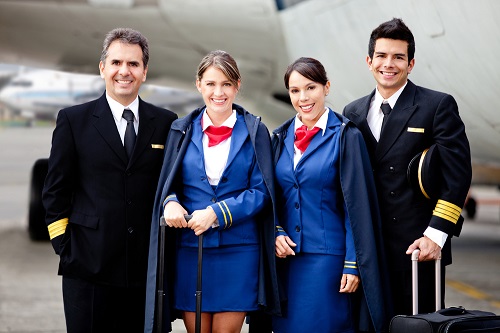 Airline captain and cabin crew standing near the plane