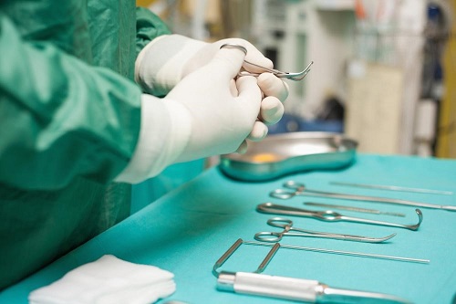Surgeon holding medical tools