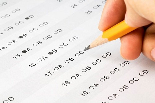 Student filling an answer sheet with a pencil