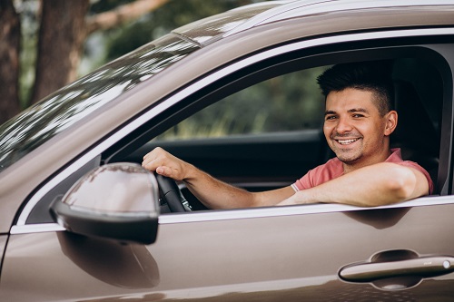 Young handsome man sitting in car